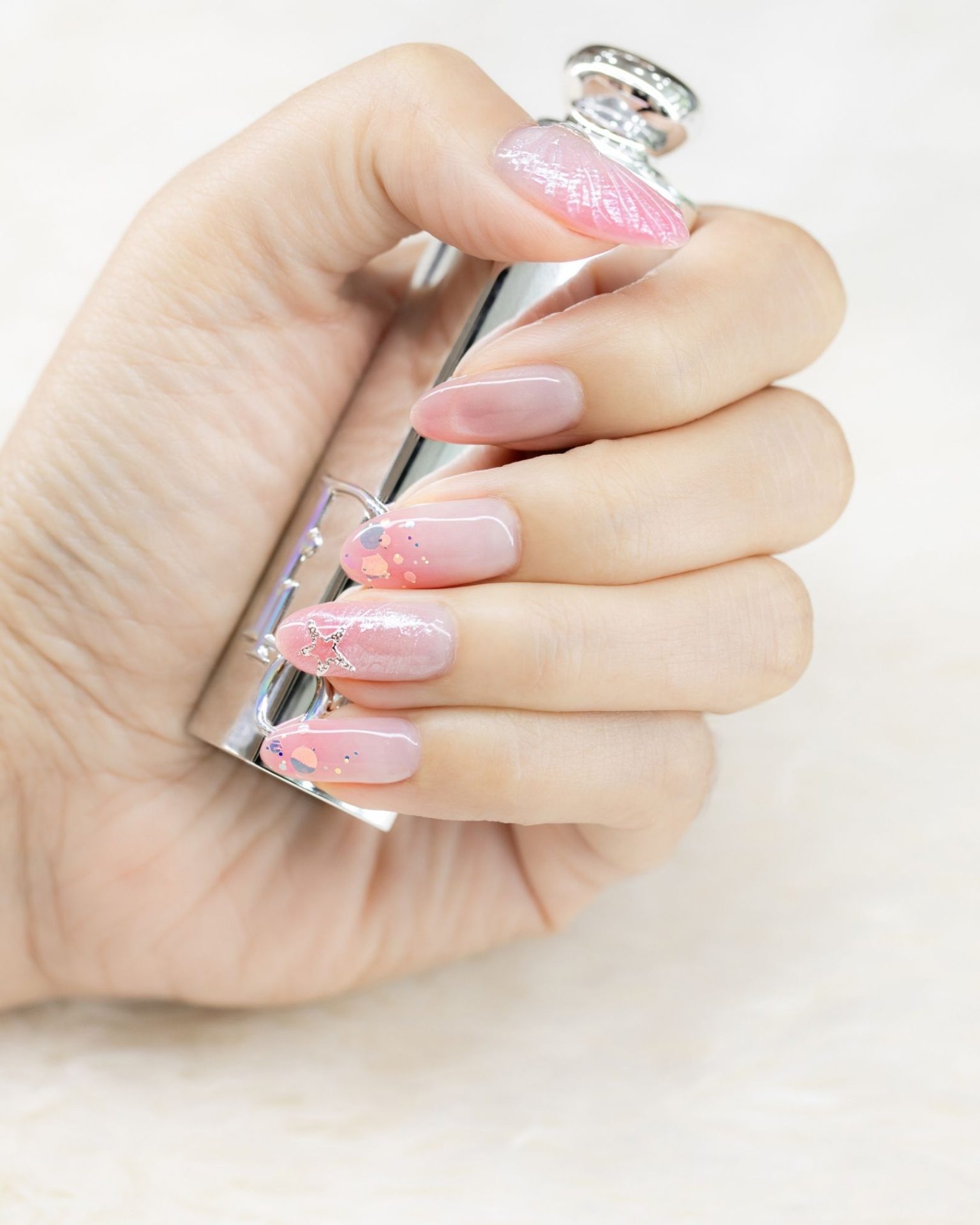 Pink ombre nail art decorated with stars and glitter