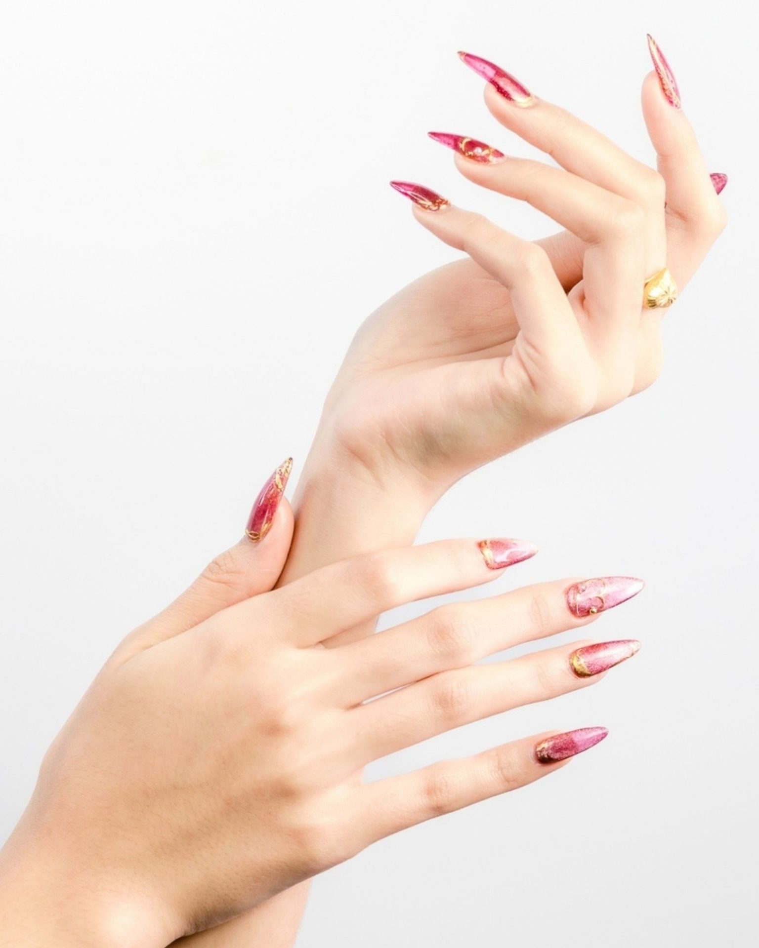 Stiletto nails in metallic pink with luxurious gold-lined edges
