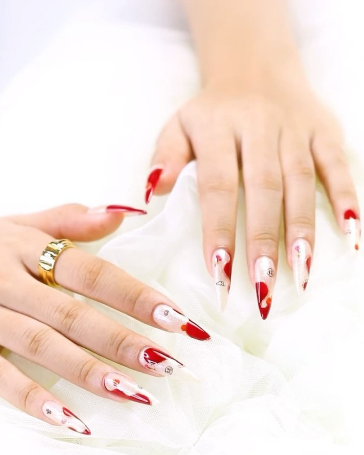 Stiletto nails painted with alternating red and white design, minimalist style