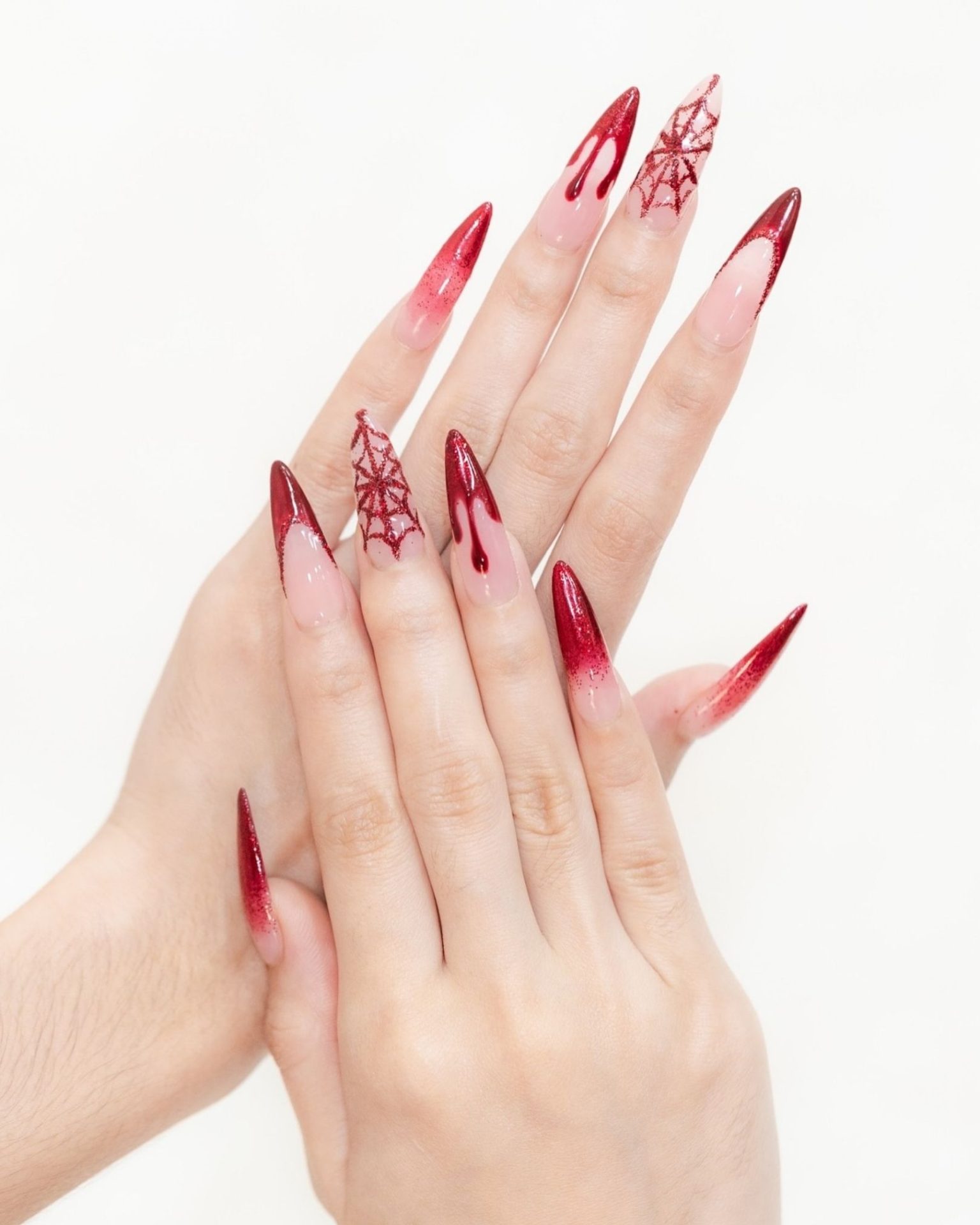Stiletto nails painted with drip-blood and red glitter spiderweb design