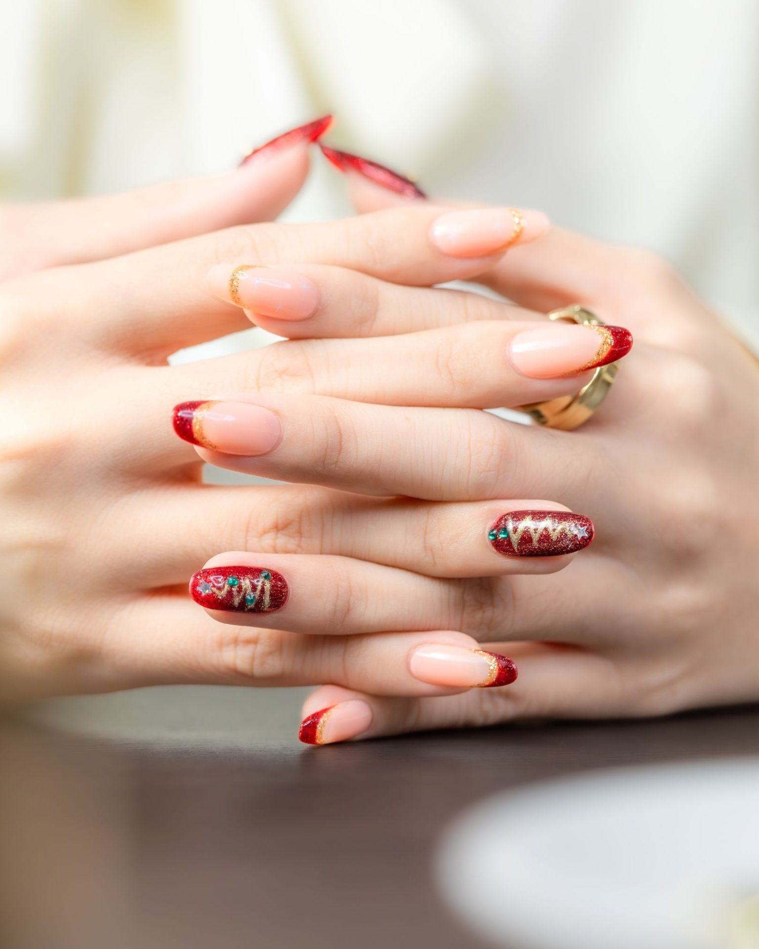 Red glitter tip nails lined with gold, decorated with Christmas tree line design