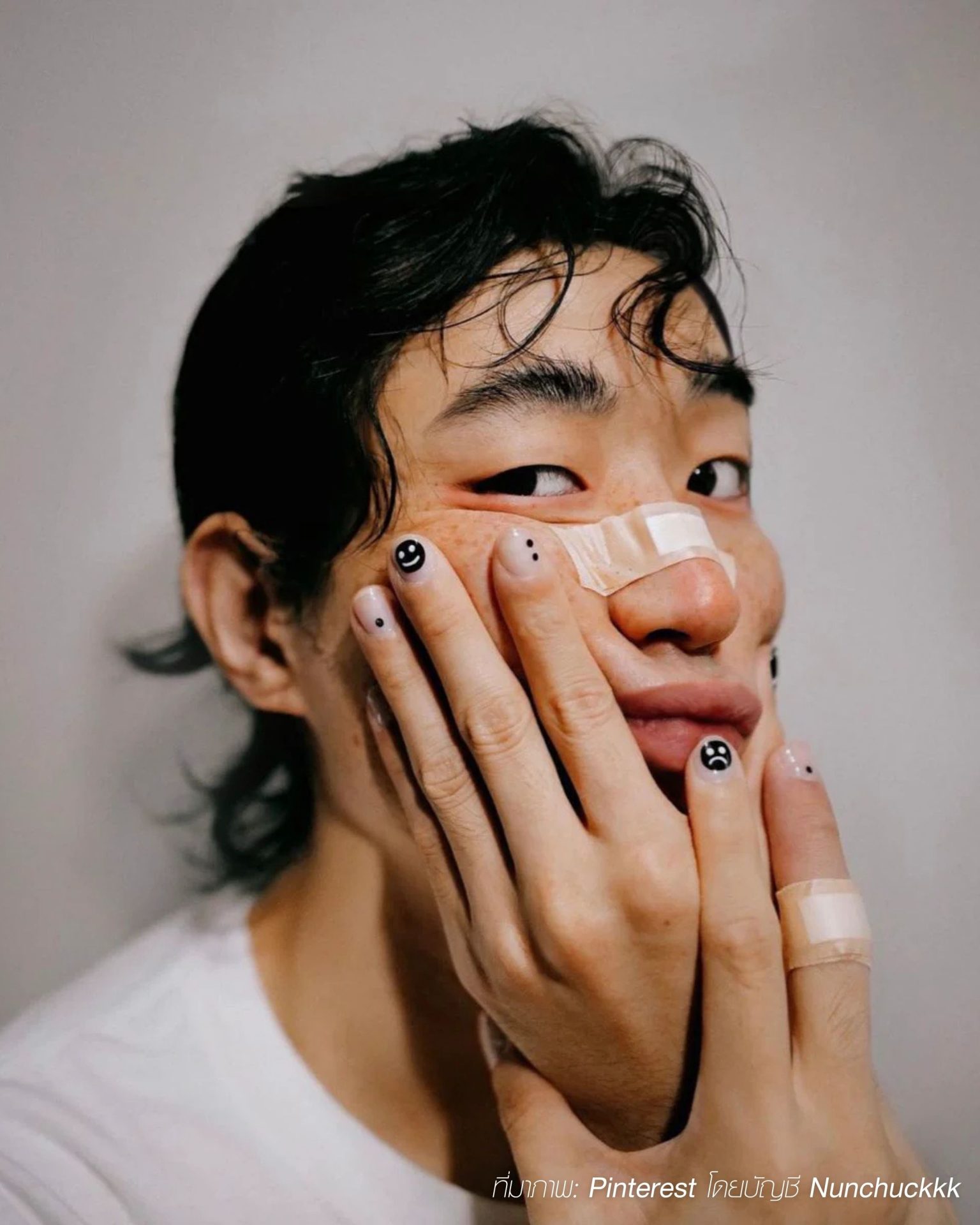 Minimalist men's nails painted with simple black smiley and sad face lines