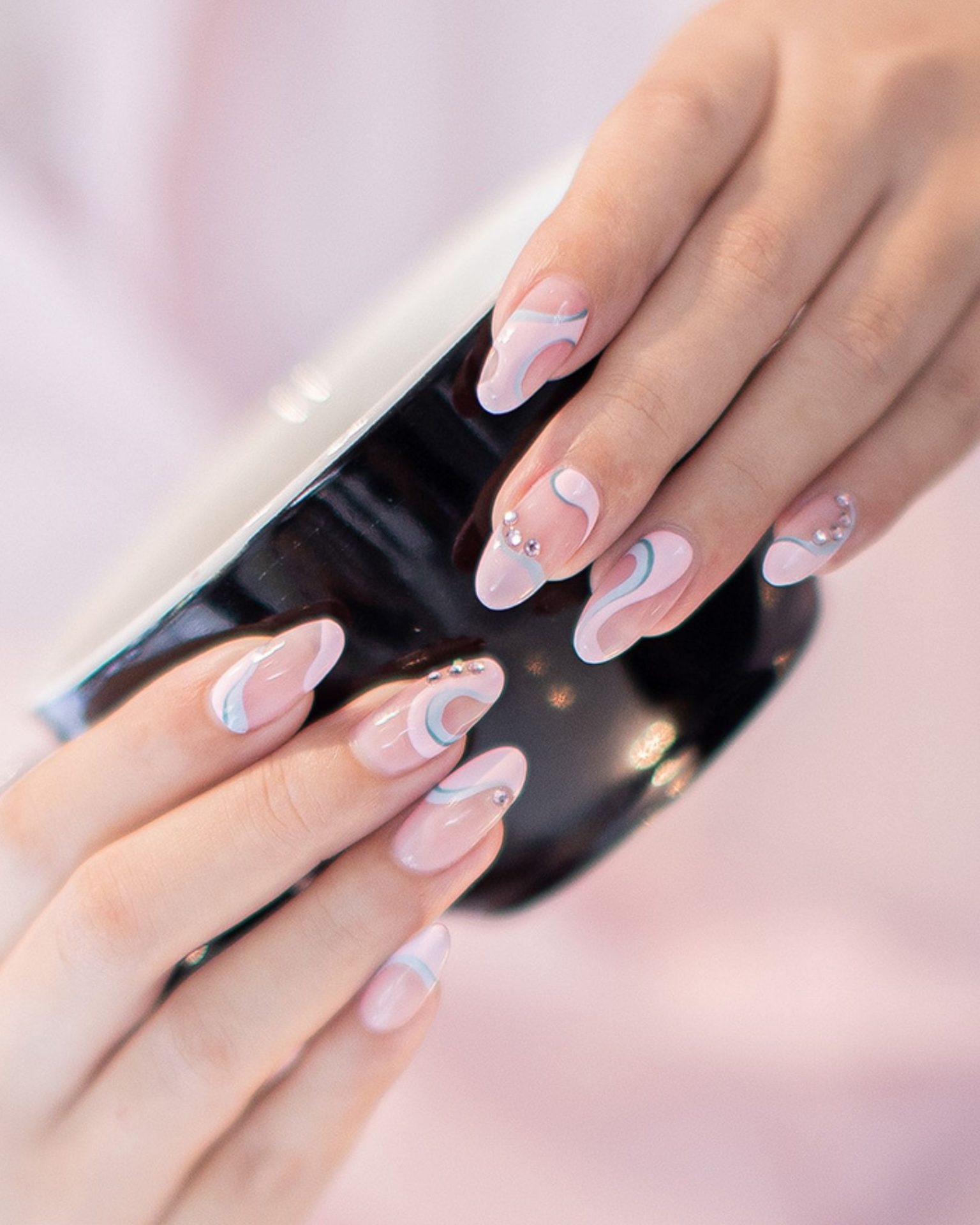 Pastel curved line nail art decorated with luxurious-looking crystals