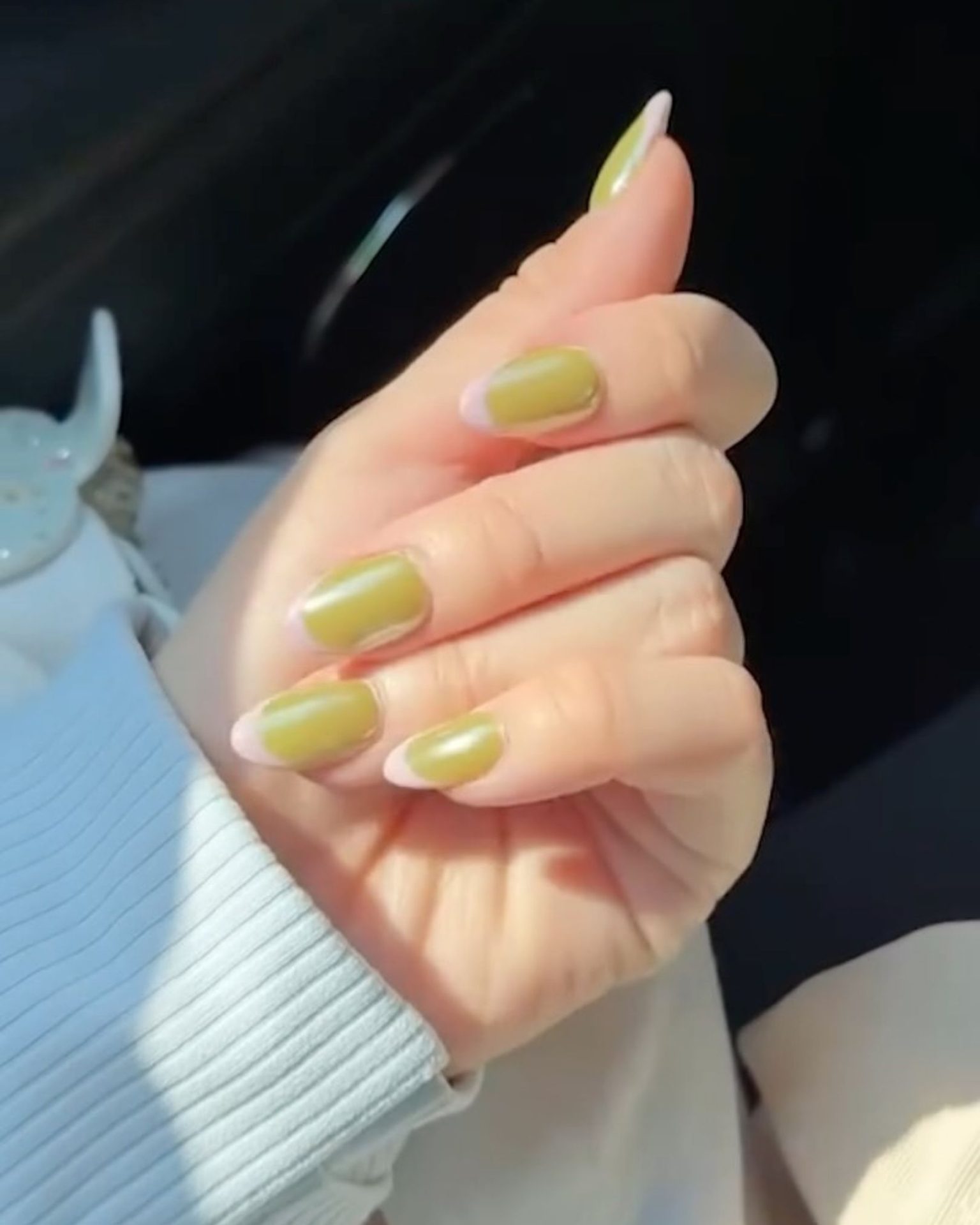 Short round nails with olive green French tip for a simple yet modern look