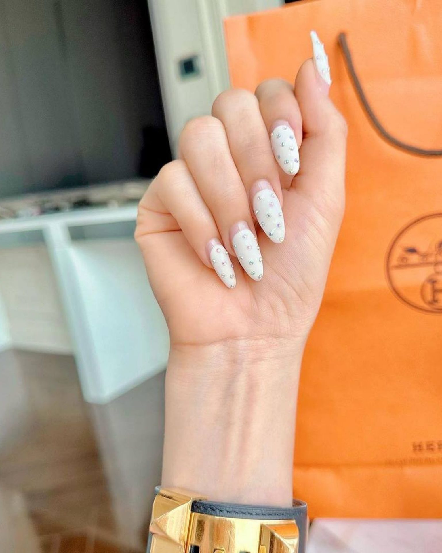 White nails decorated with beautifully arranged crystals