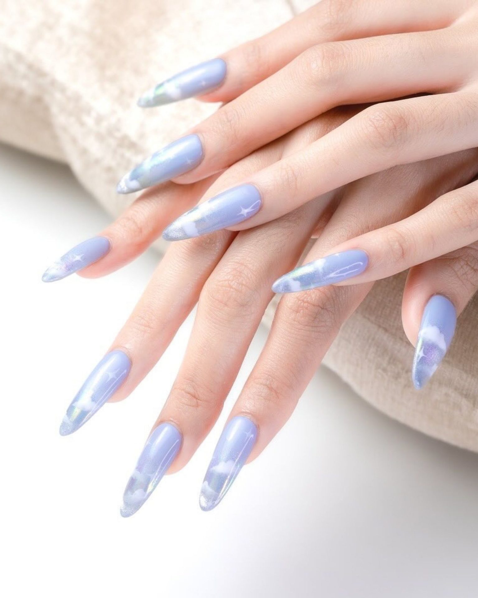 Light blue nails painted with clouds and stars
