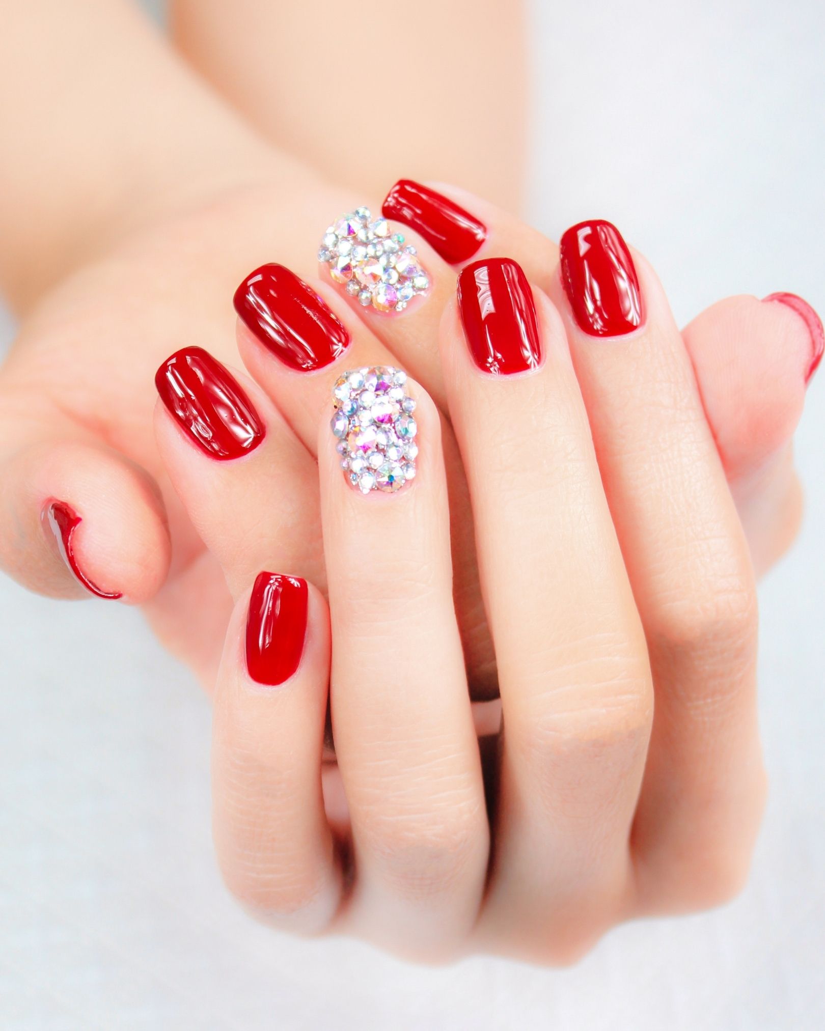 Bright red luxe nails, middle and ring fingers decorated with full-coverage crystals, expensive-looking design