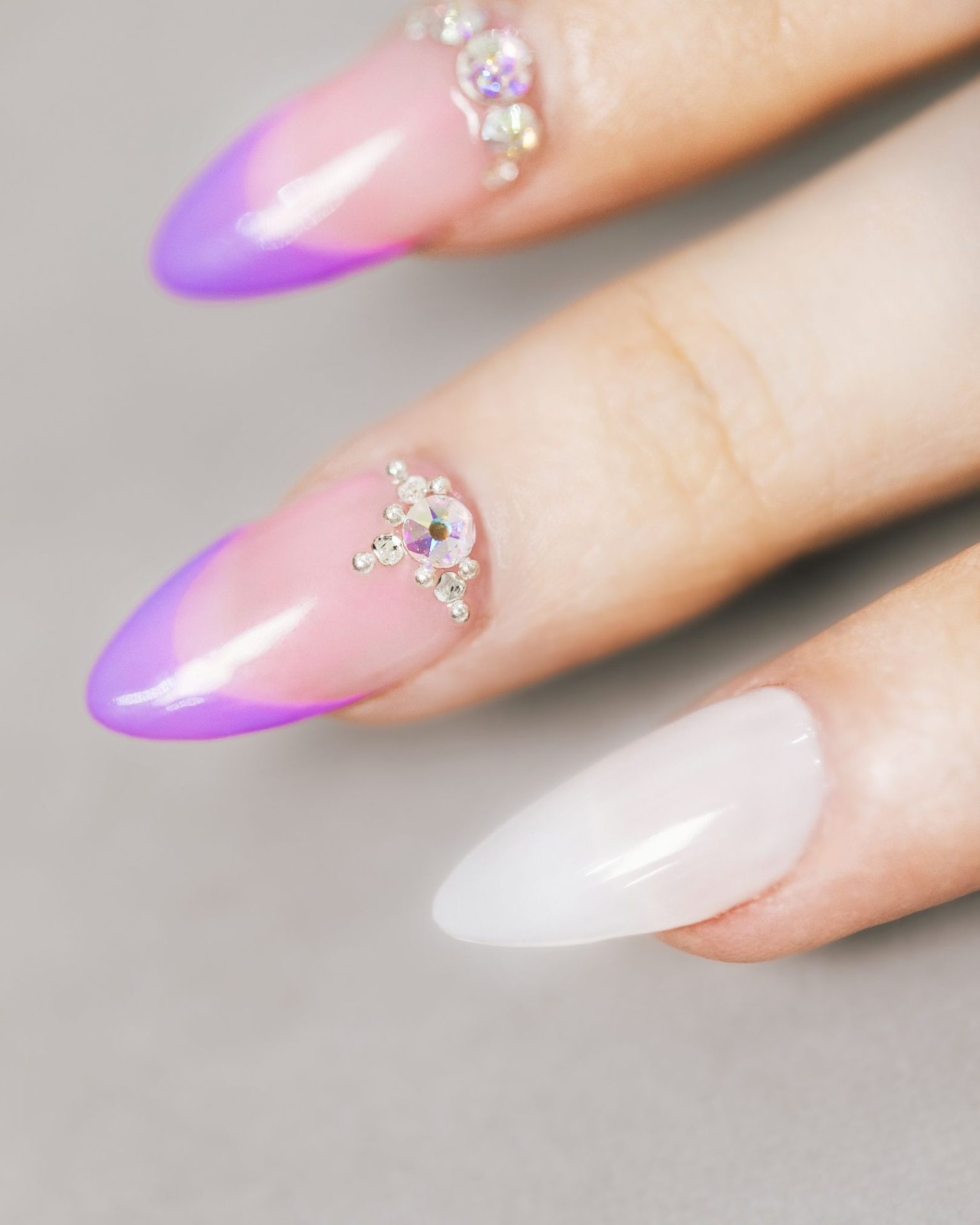 French tip nails with purple tip decorated with large crystals