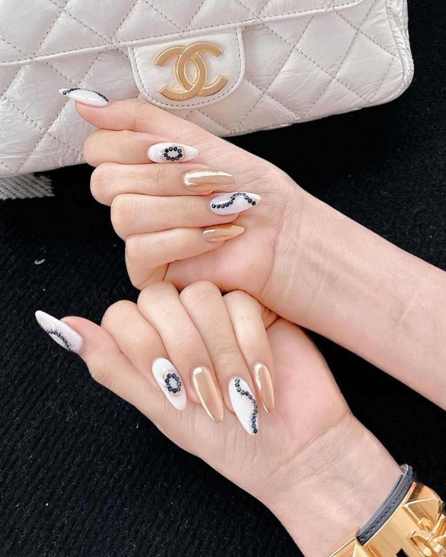 White tone nails decorated with crystals and gold patterns