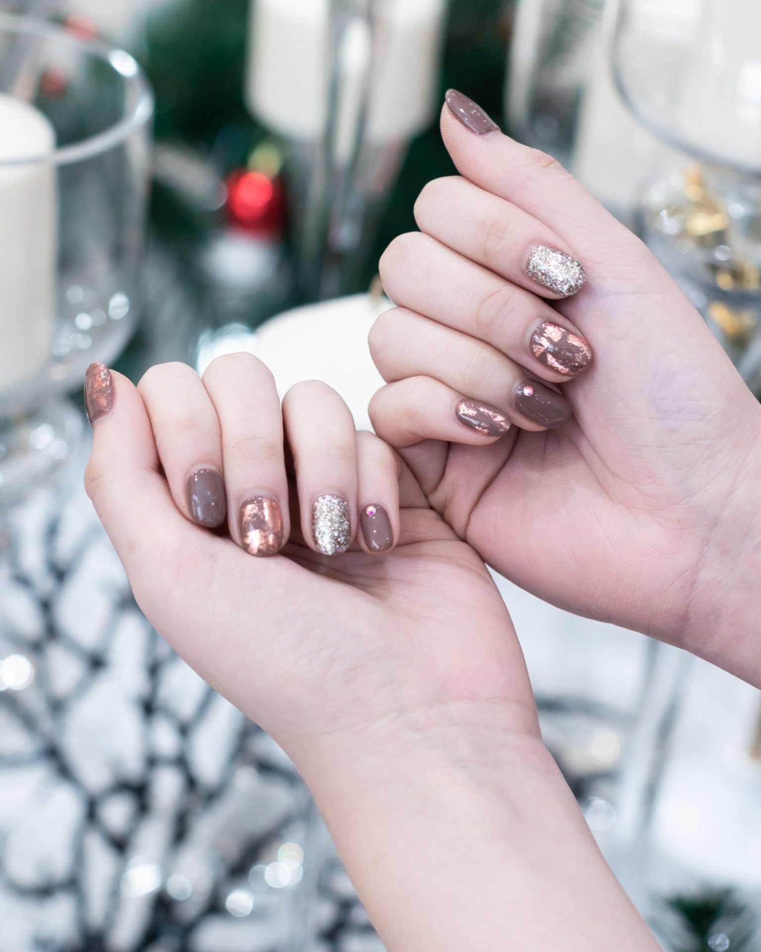 Copper and bronze tone nails decorated with fine glitter and small crystals for a sparkling luxe look