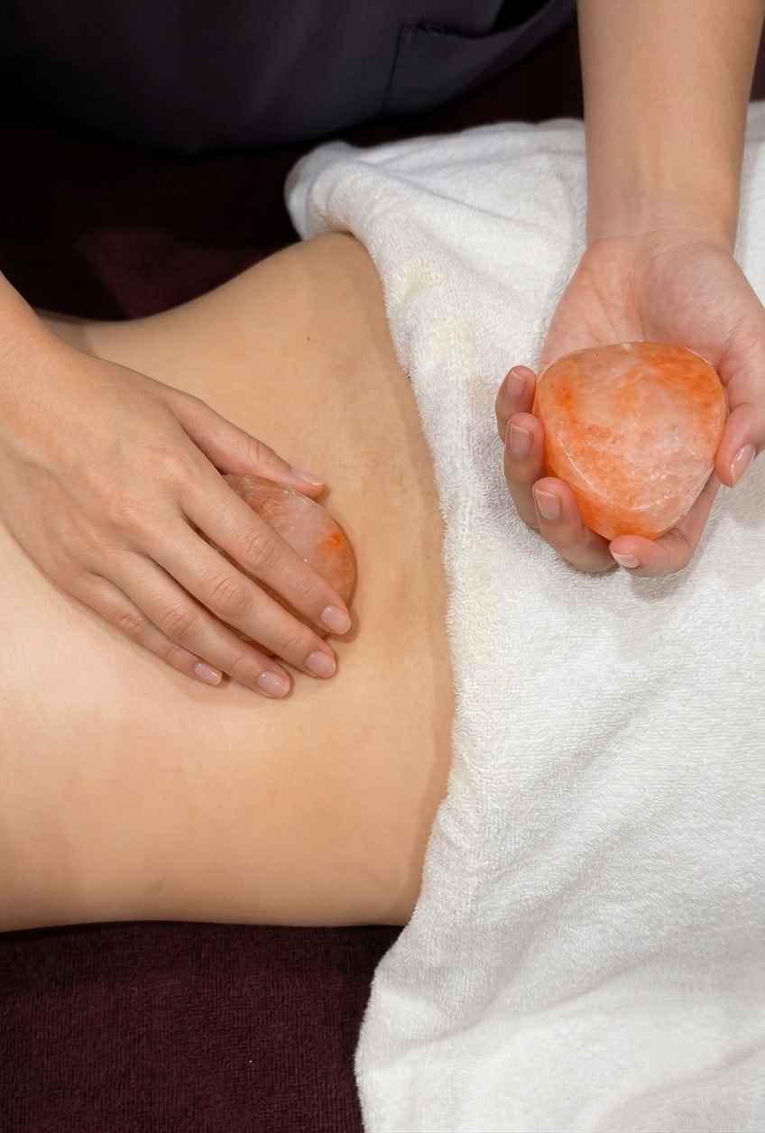 Heart-shaped Himalayan salt stone used for muscle-relaxing massage, warmed with natural heat