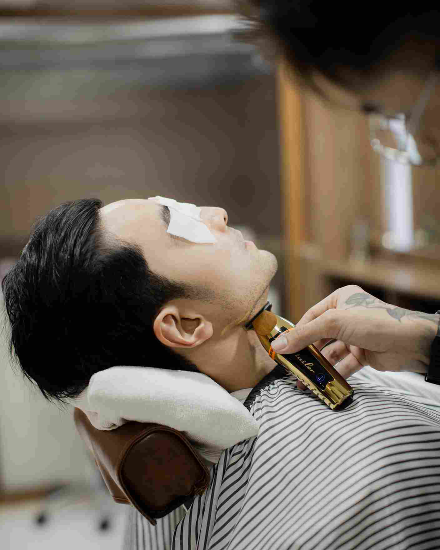 Barber shaping a man's beard at One Man Club, Sukhumvit 35, Bangkok