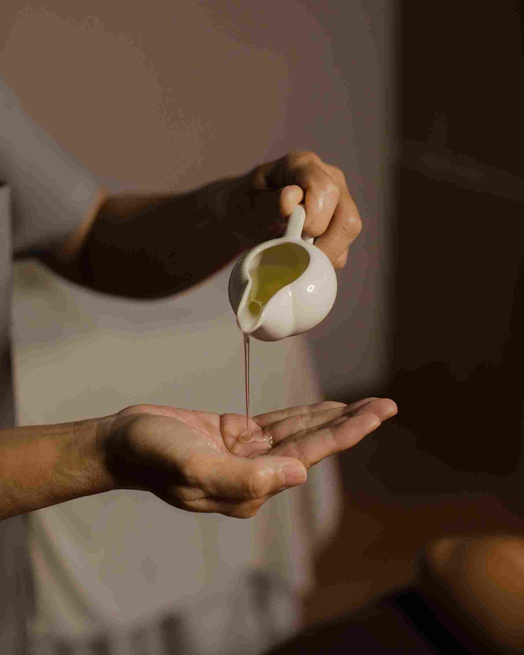 Therapist preparing warming recovery oil before a sports massage session